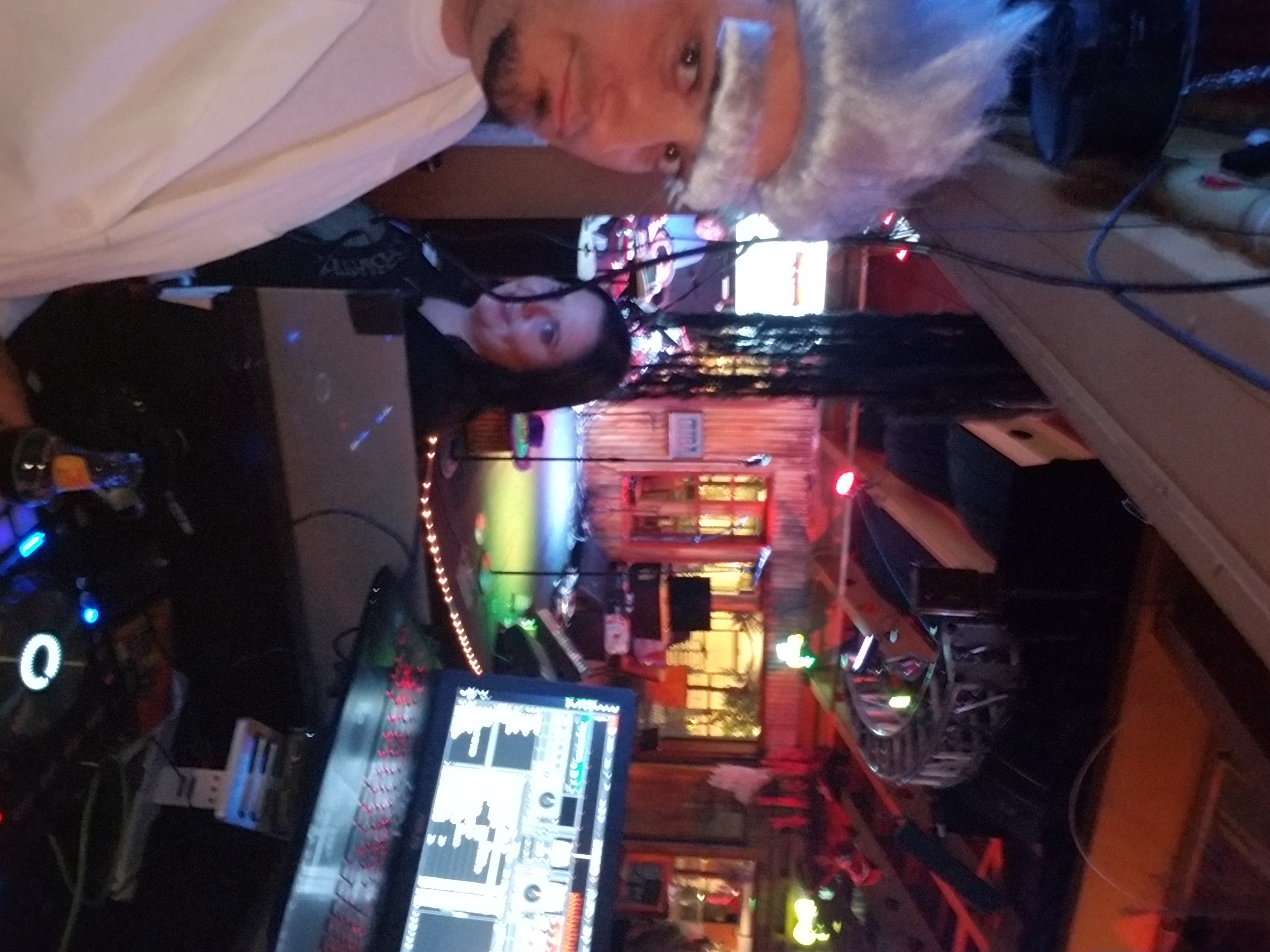 Halloween night in the DJ booth with guests and the club lit up behind the setup