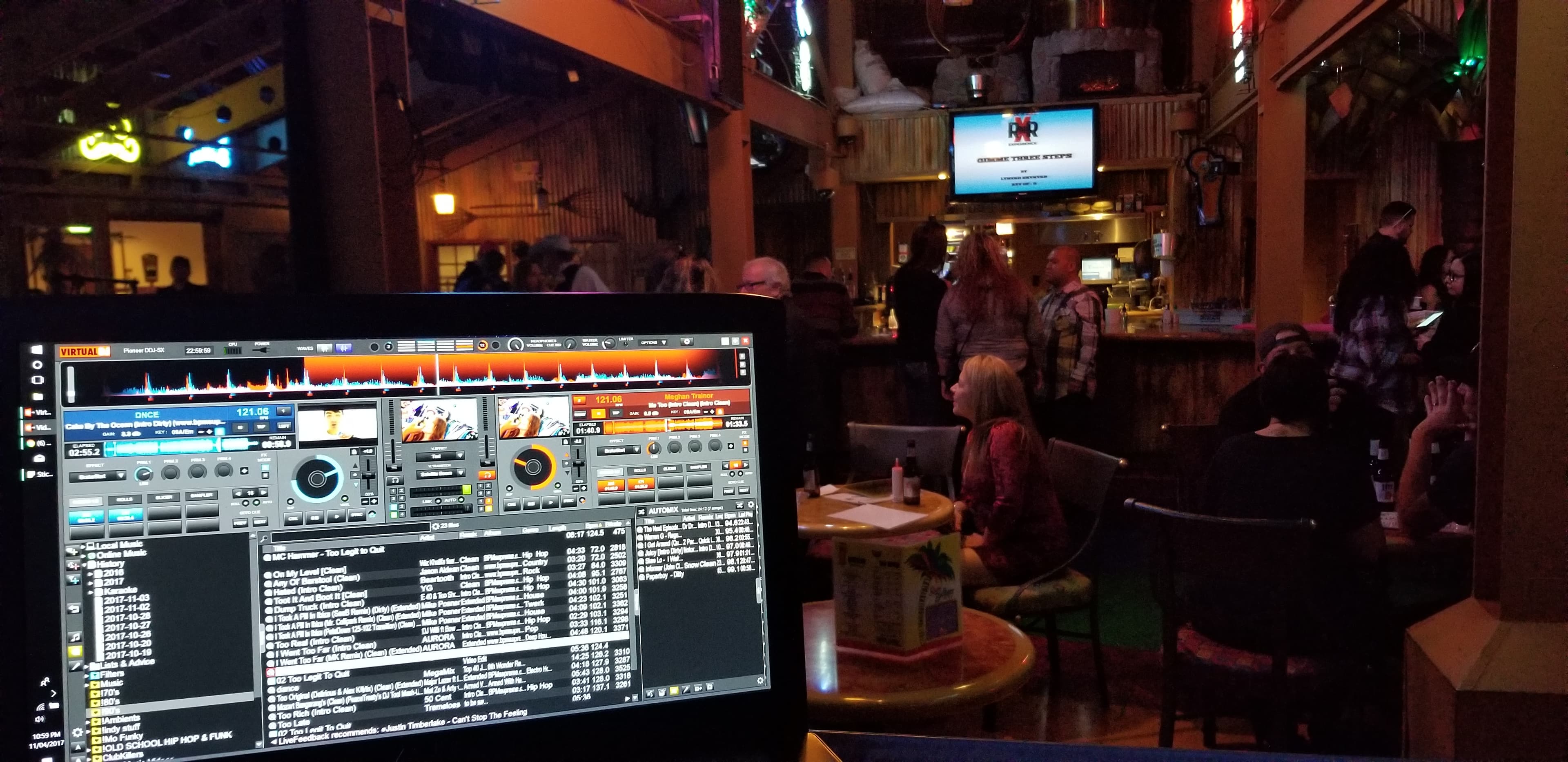 DJ laptop overlooking the Rumbullions bar room with guests seated at tables