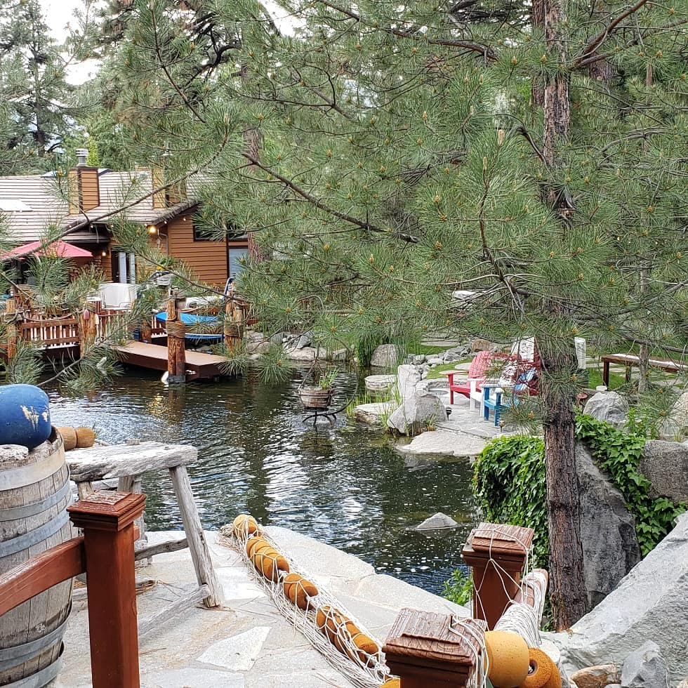 Lakeside cabin venue with dock, Adirondack chairs, and pines — private event setting